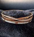 Rose gold bracelet with diamond accents on a black fur surface