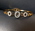 Gold bracelet with circular design on a dark background