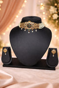 Jewelry set including a choker and earrings on a black stand with a blurred decorative background.
