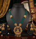 Gold and green necklace set on a black mannequin with matching earrings.