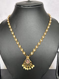 Gold necklace with a pendant on a black mannequin