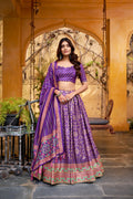 Woman in a traditional purple and pink lehenga standing in front of an archway.