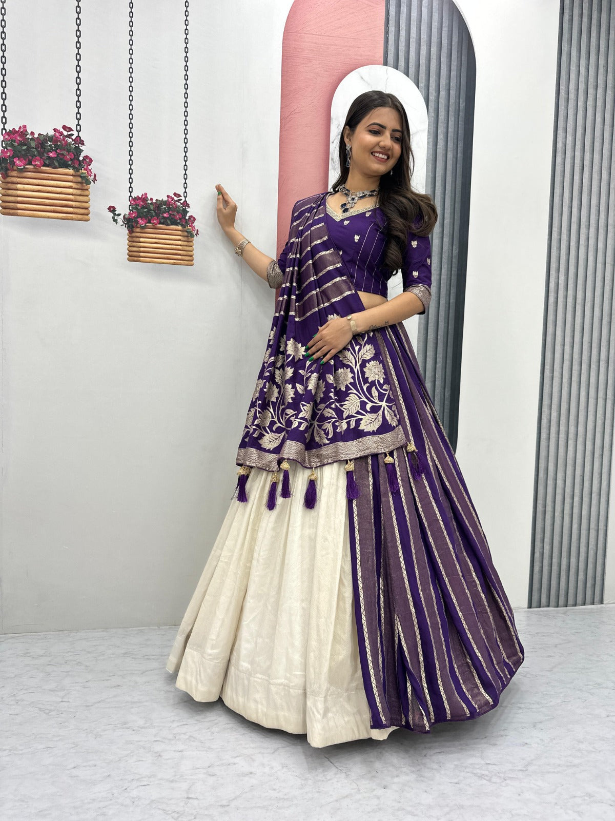 Woman in a purple and white traditional outfit standing in front of a mirror.